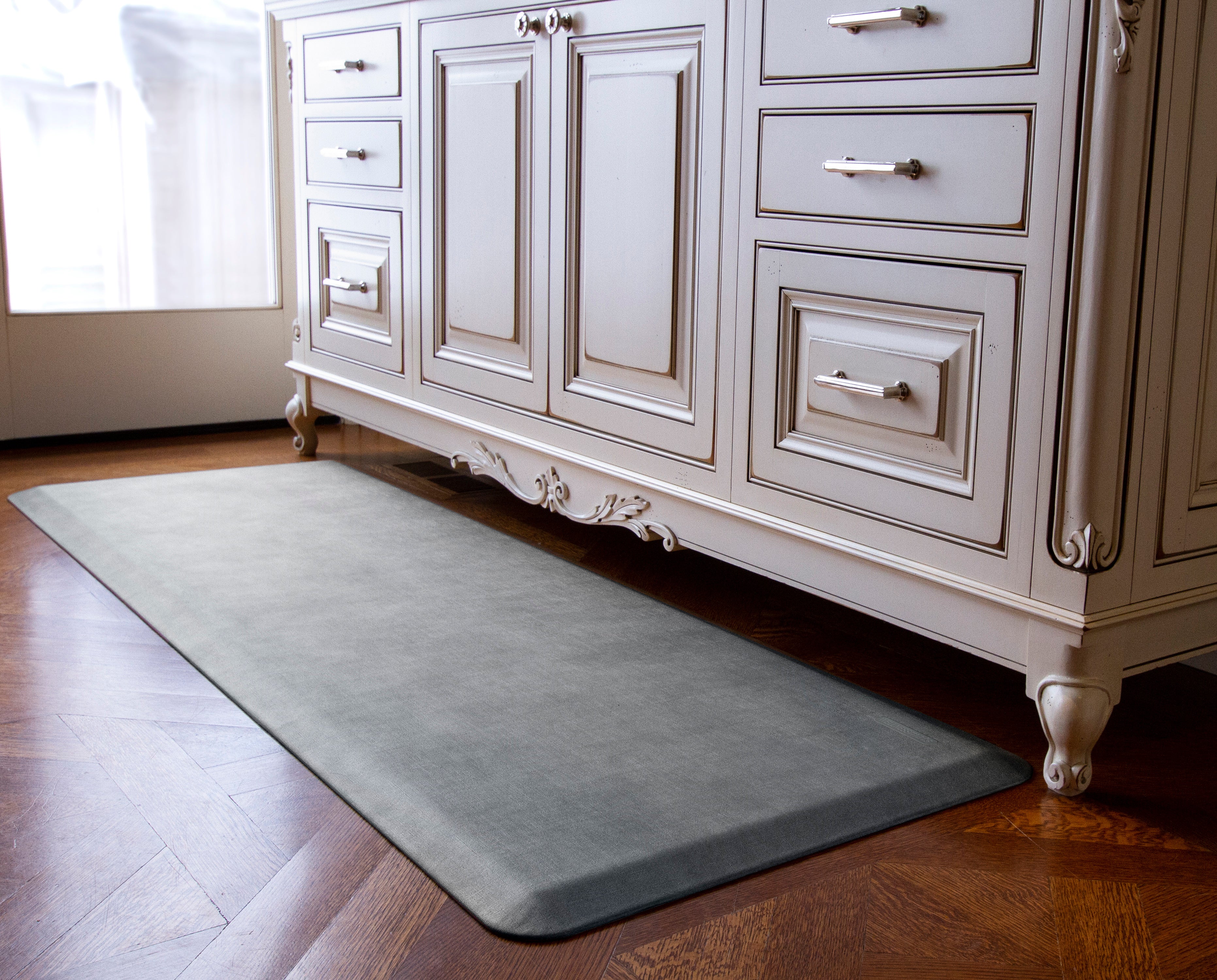 A 6'x2' Linen Slate WellnessMat in front of a white vanity.