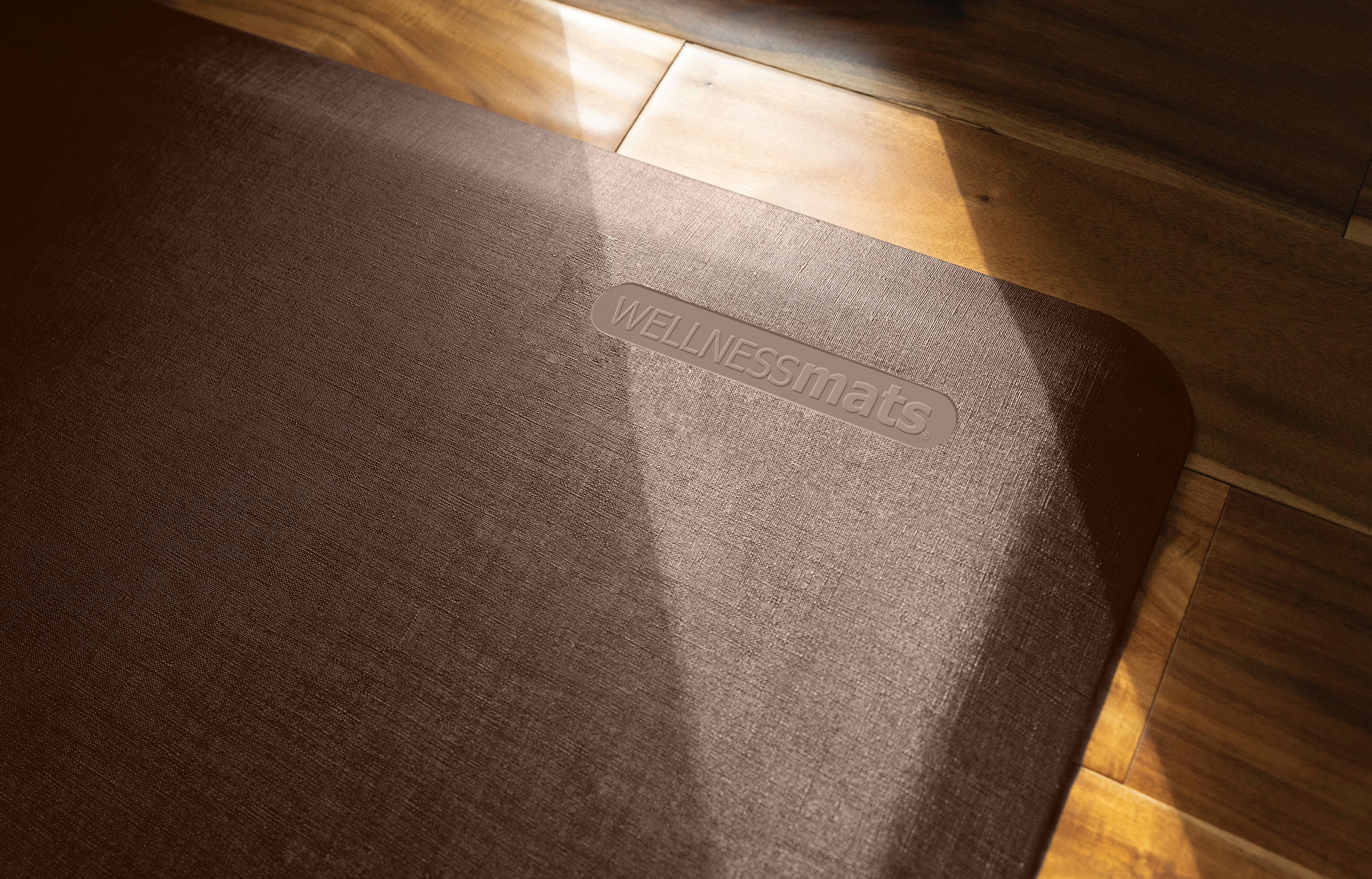 An up-close shot of a 3'x2' Antique Dark WellnessMat in a sunbeam.
