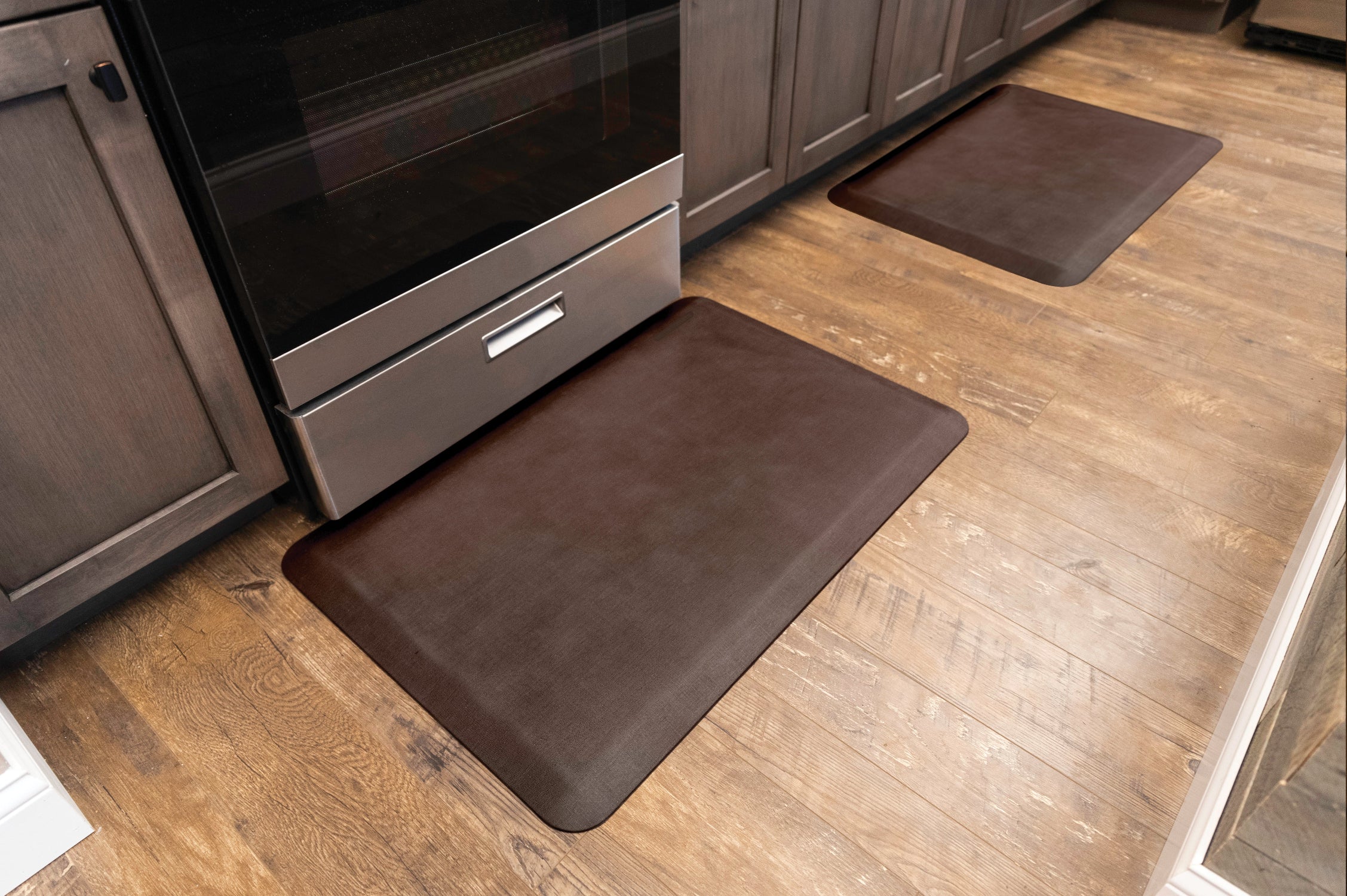 Two 3'x2' Antique Dark WellnessMats in a kitchen.