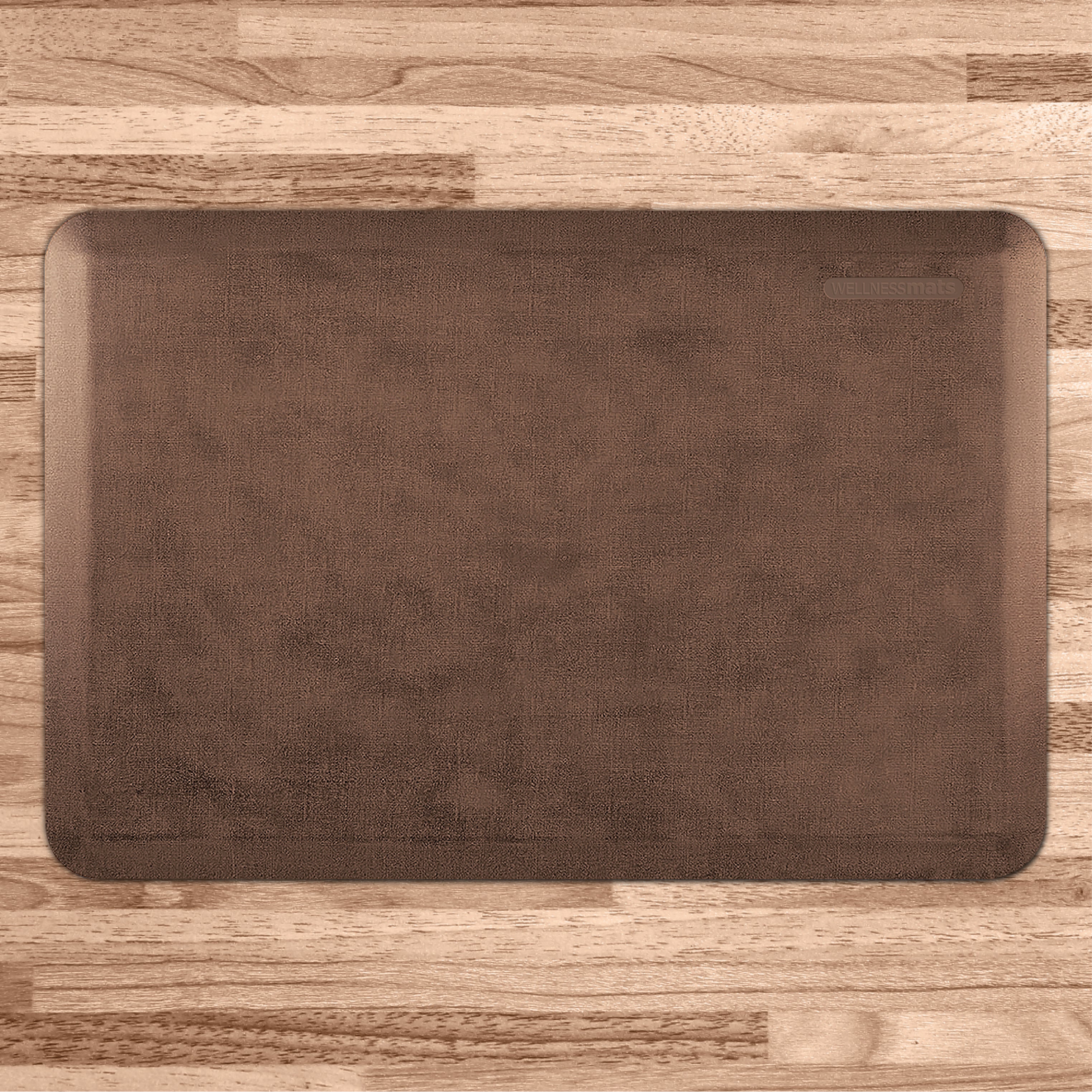 A 3'x2' Antique Light WellnessMat on a light wood floor.