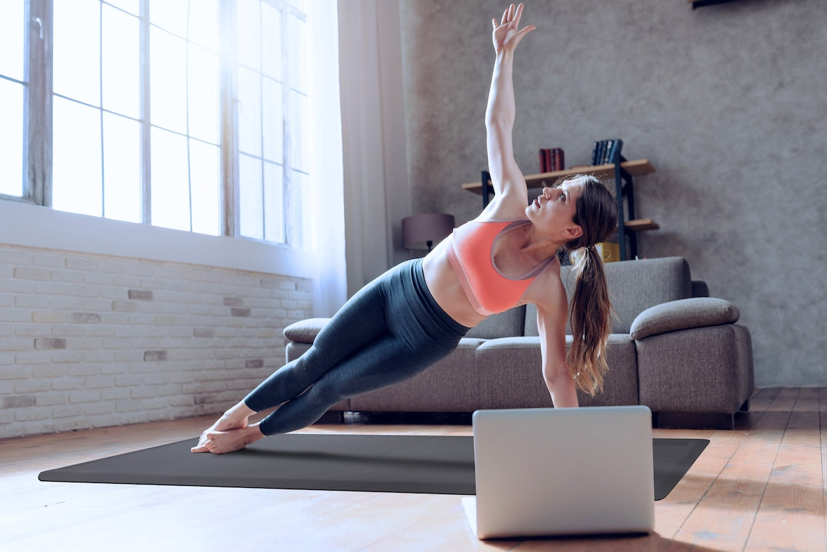 Woman on gray FitnessMat in living room