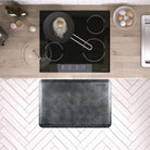 A 3'x2' Linen Onyx WellnessMat in front of a kichen stove.