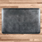 A 3'x2' Linen Onyx WellnessMat on a light wood floor.