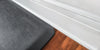 A up close shot of a 3'x2' Linen Slate WellnessMat on a wood floor.