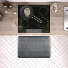 A 3'x2' Linen Slate WellnessMat in front of a kitchen stove.