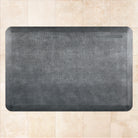 A 3'x2' Linen Slate WellnessMat on a tile floor.