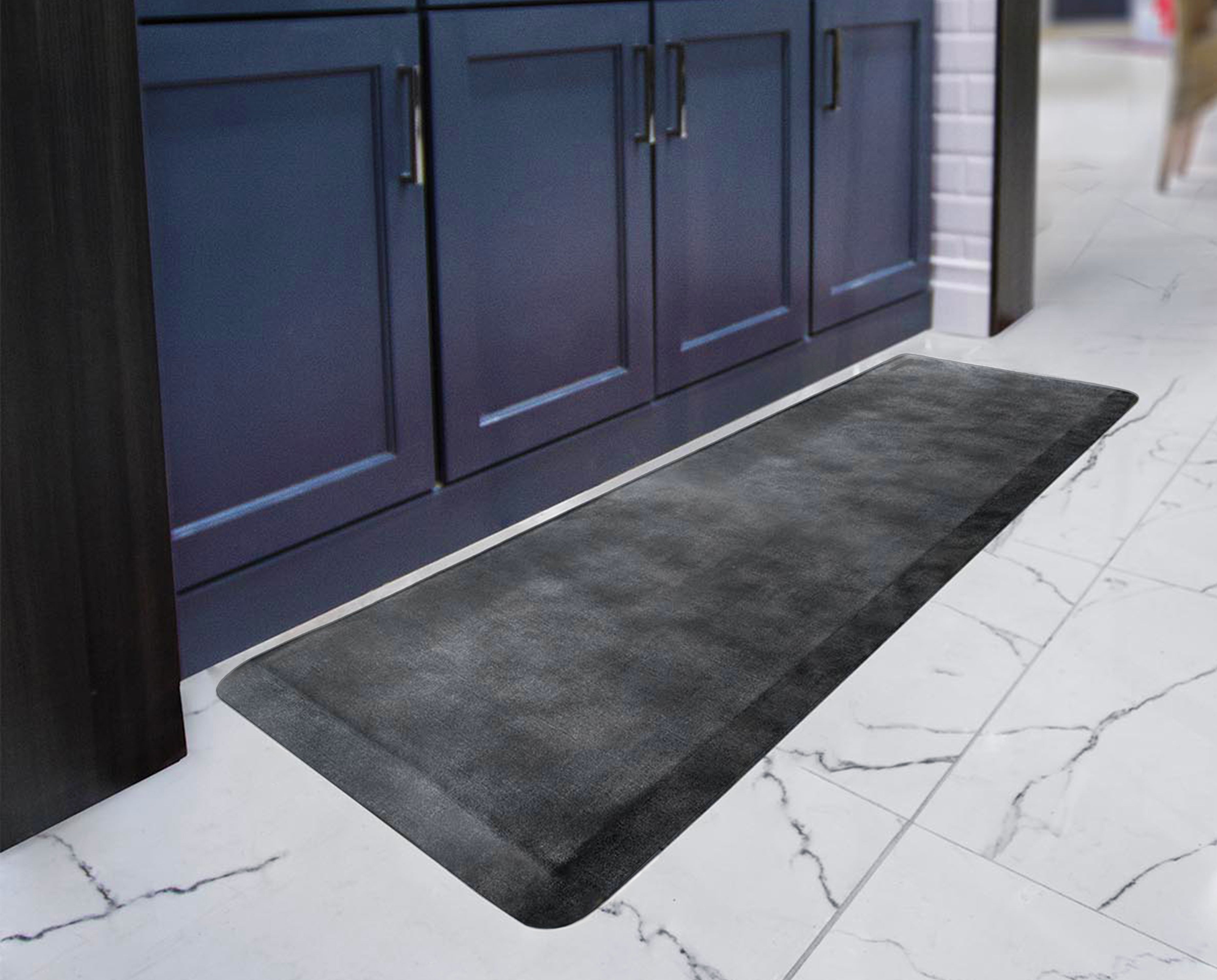 A 6'x2' Linen Onyx WellnessMat in front of a blue vanity.