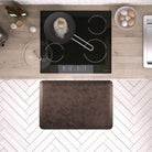 A 3'x2' Antique Dark WellnessMat in front of a kitchen stove.