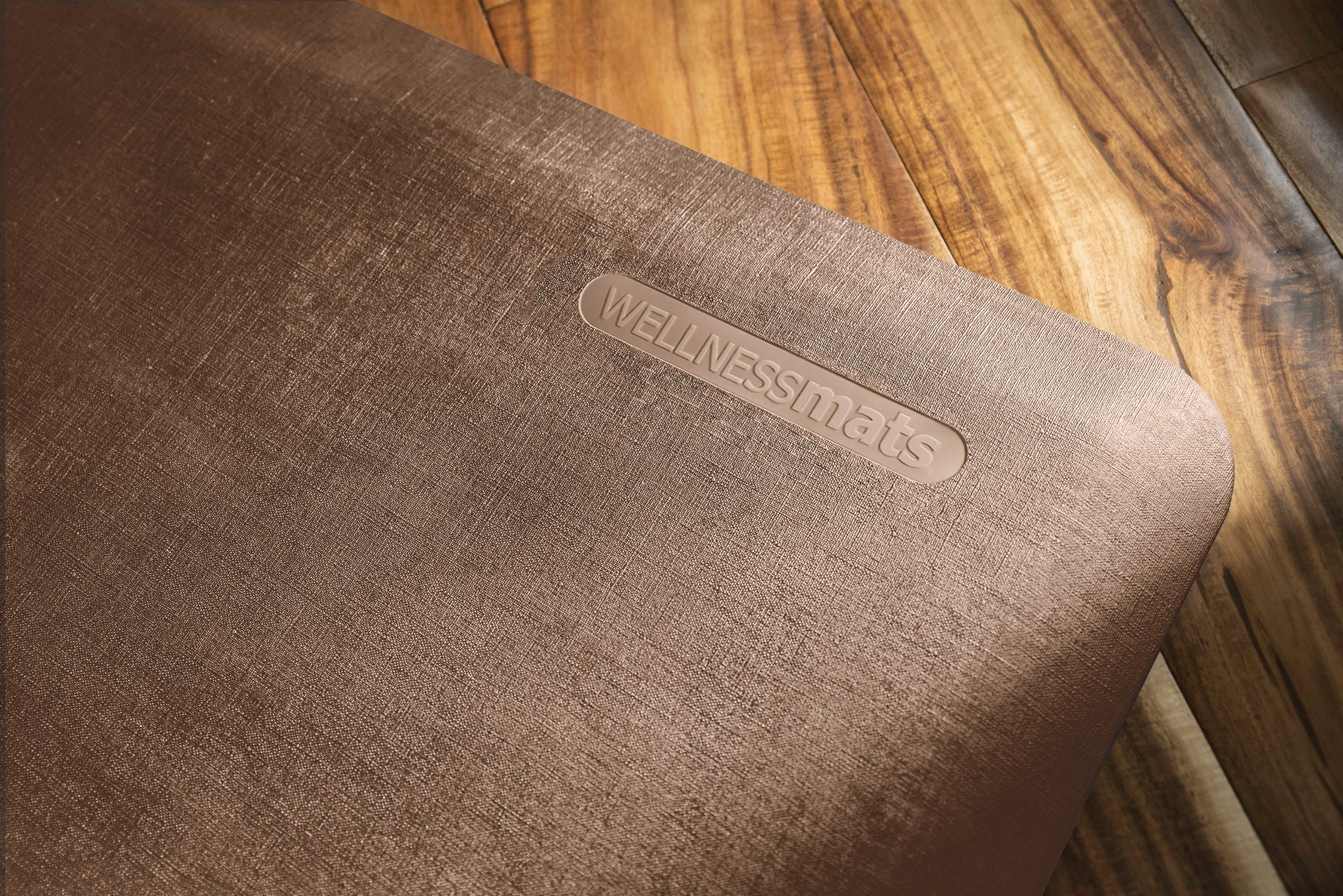 An up-close shot of 3'x2' Antique Light WellnessMat on a light wood floor.