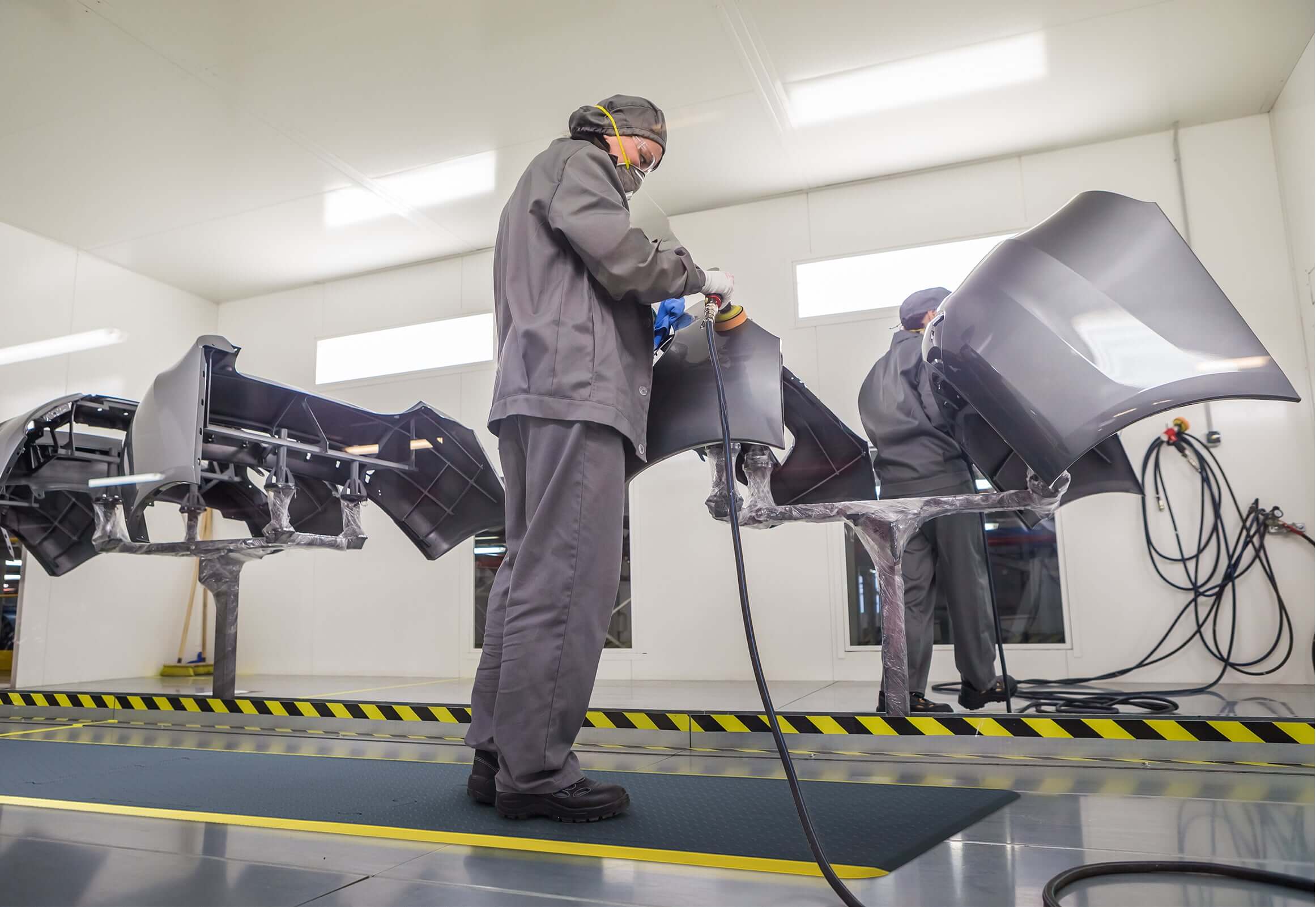 Technicians working on Connect Custom product parts in a modern manufacturing facility.